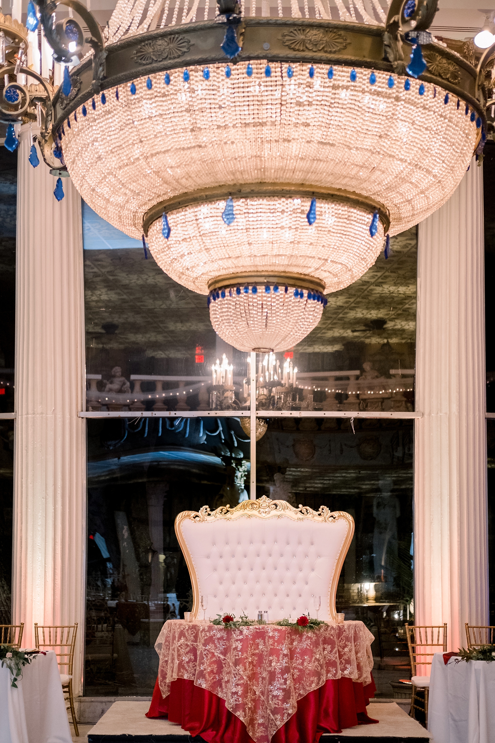 The bride and grooms sweetheart table under the giant chandelier in the ballroom of the Kapok Tree in Clearwater, FL by Sarah & Ben Photography
