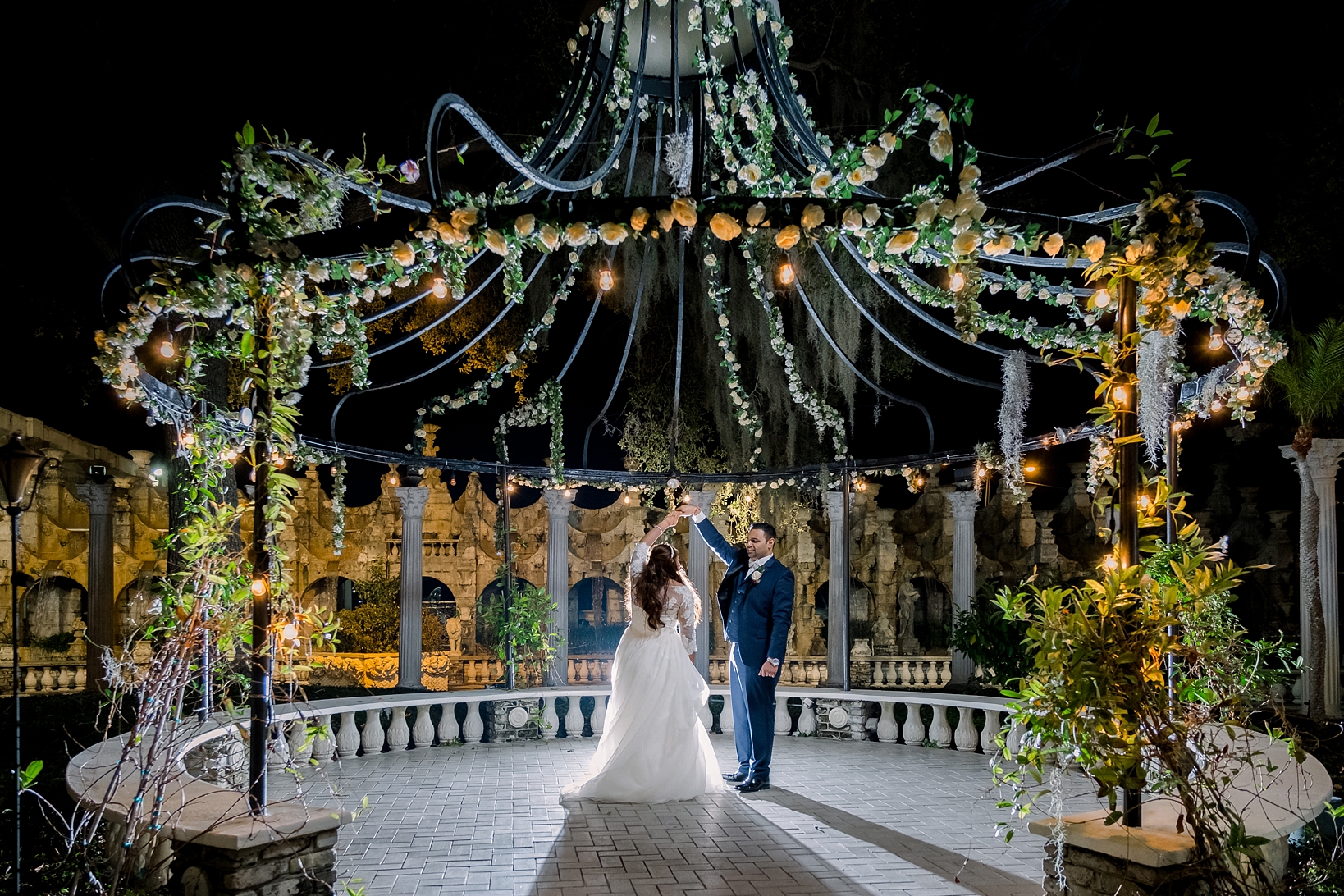 Bride and Groom share a dance in the night under the floral gazebo by Sarah & Ben Photography