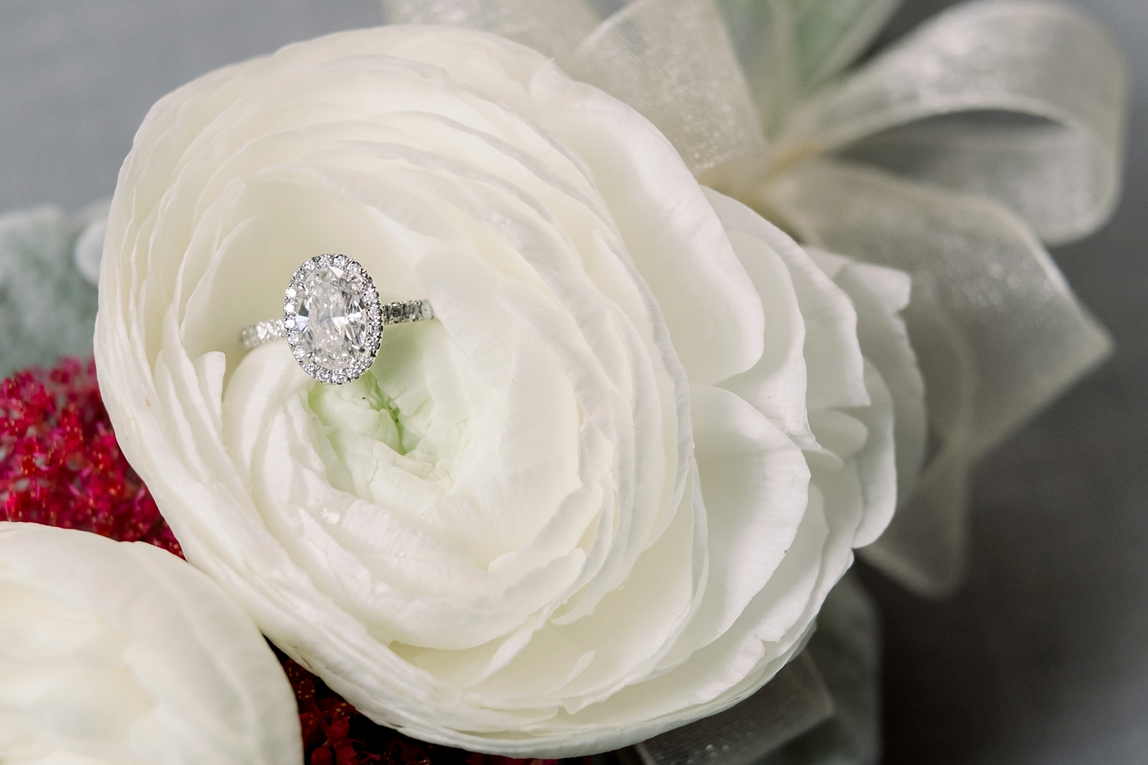 The Bride's engagement ring inside a white flower by Sarah & Ben Photography