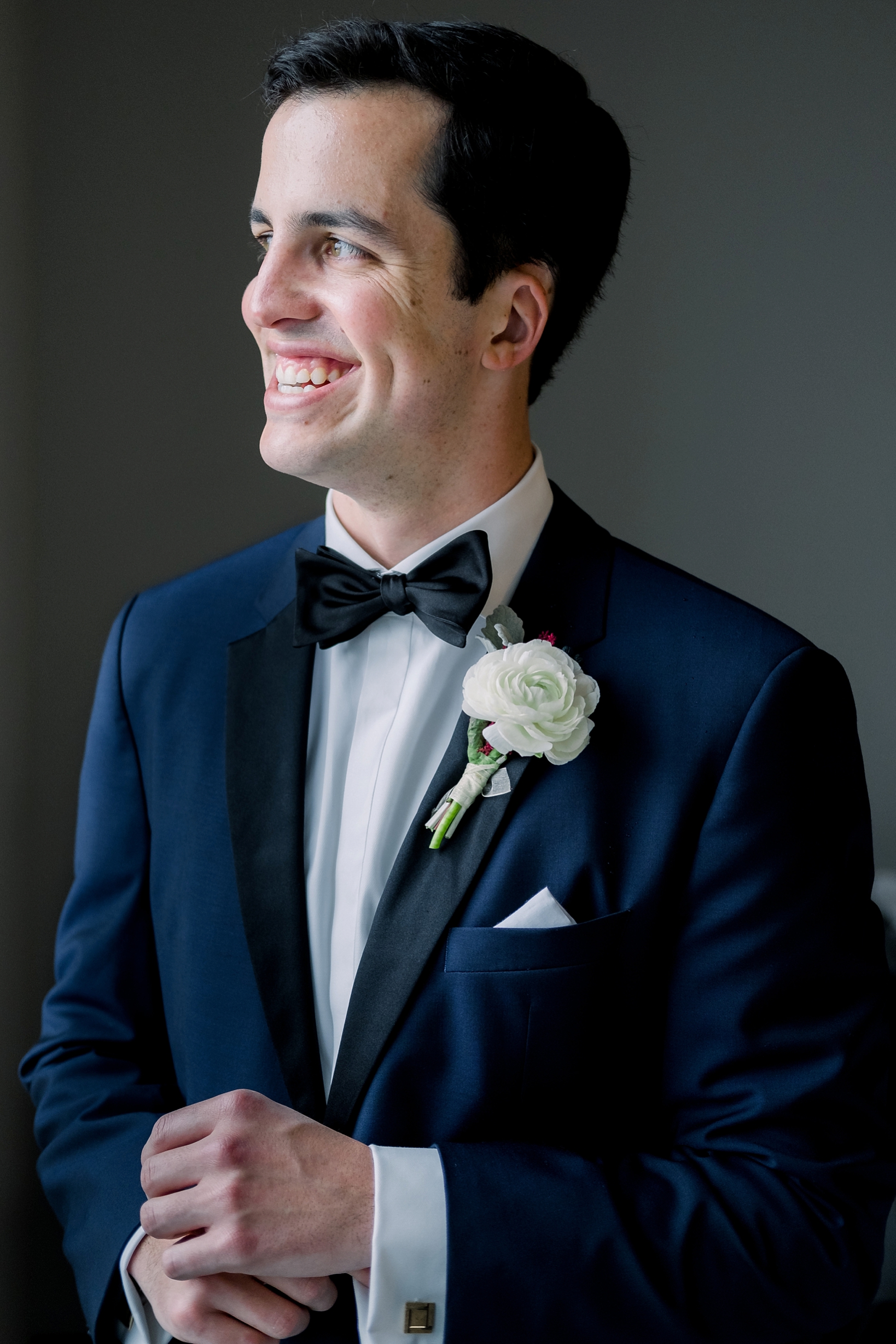 A classic portrait of the groom in his navy suit by Sarah & Ben Photography