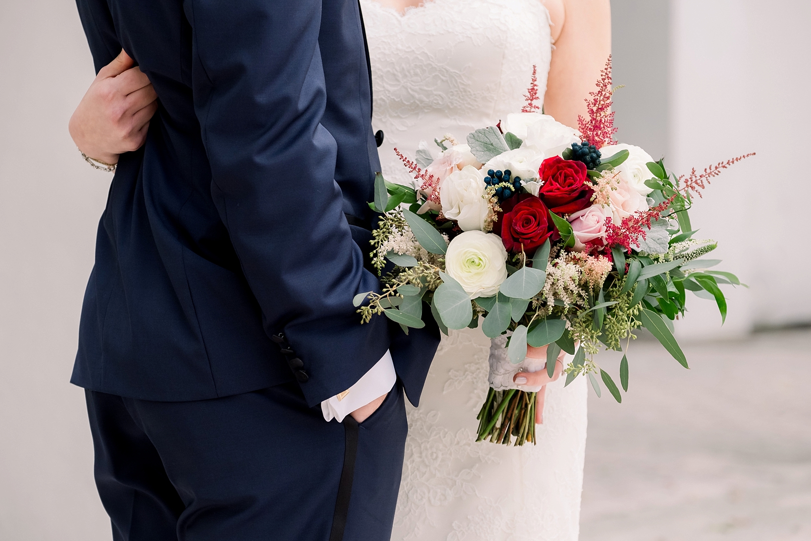 The brides florals against the white of her dress and the blue of the grooms suit by Sarah & Ben Photography