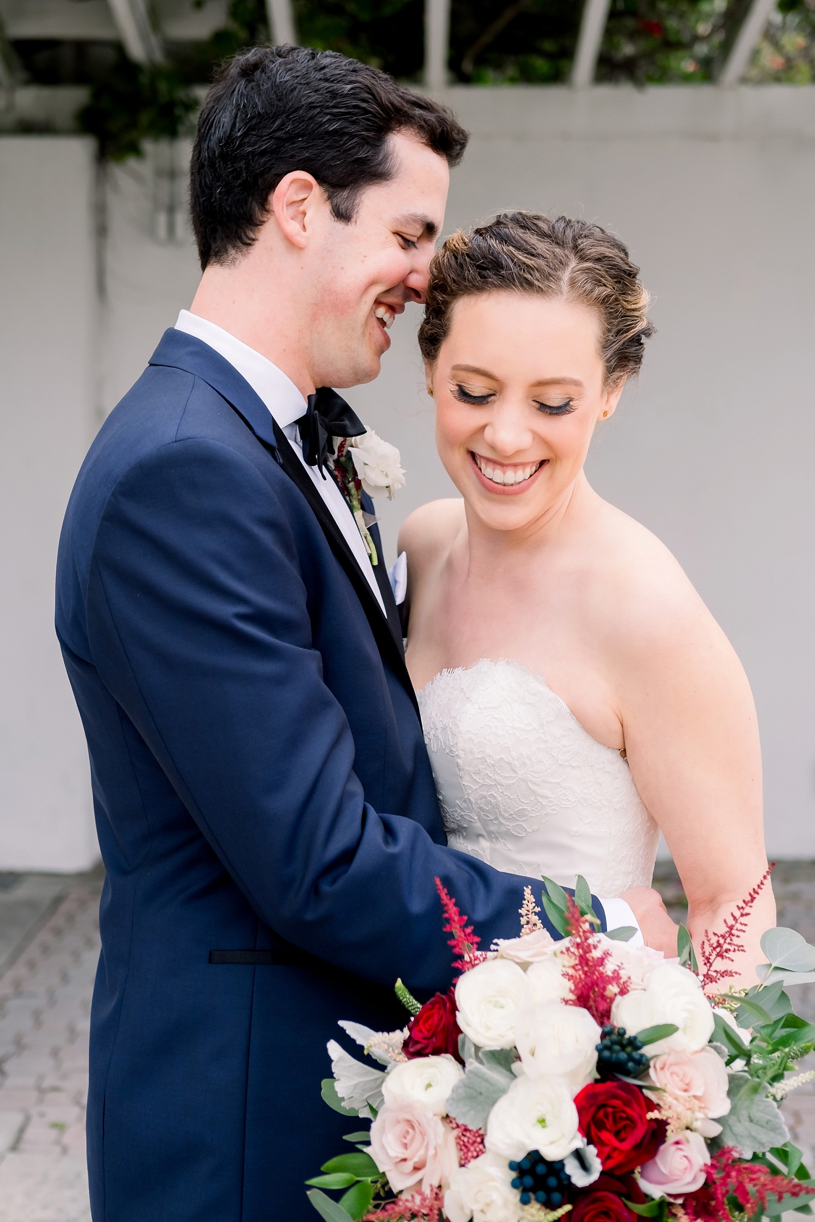 Groom laughs as he holds his bride close by Sarah & Ben Photography