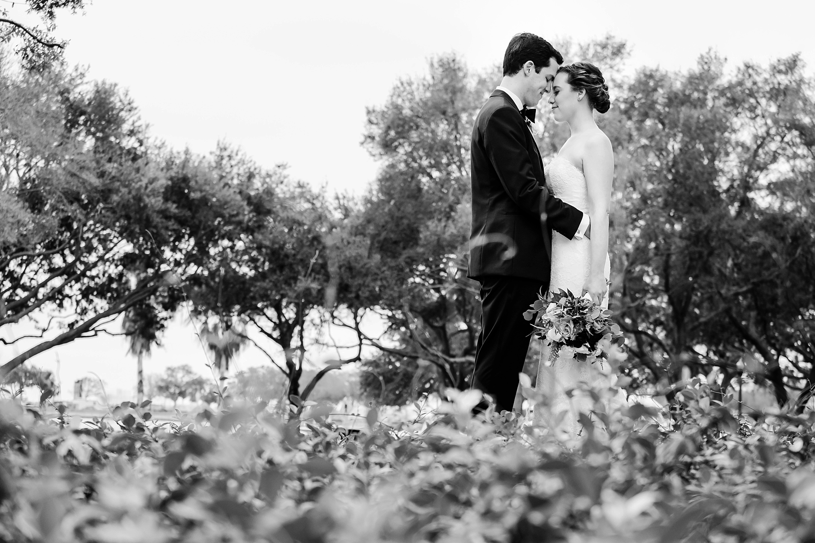Black and white picture of a bride and groom with their heads together by Sarah & Ben Photography