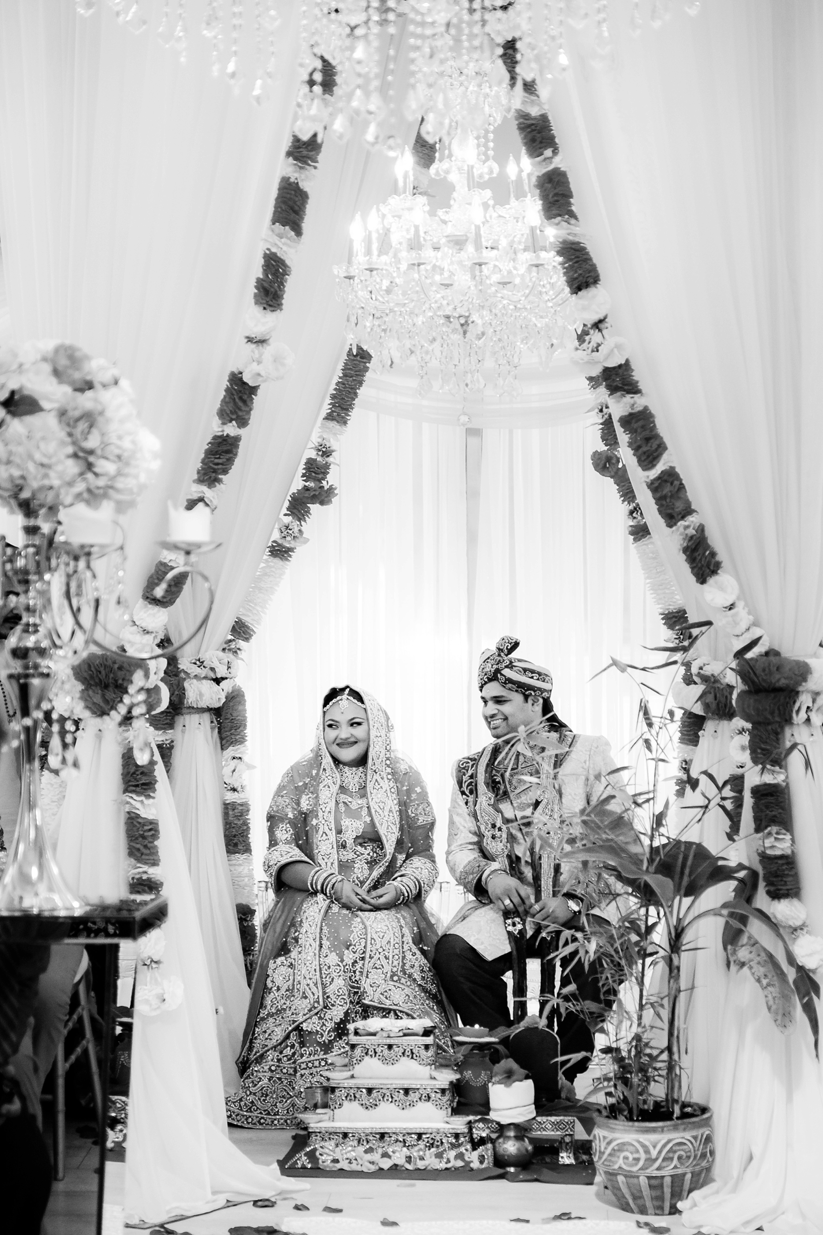 The bride and groom greet their guests under the altar in black and white
