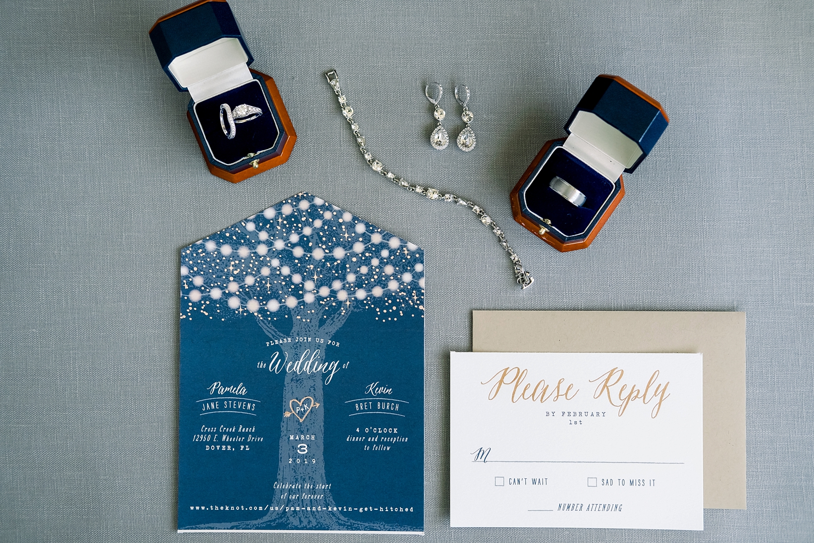 Wedding invitations surrounded by the Bride's jewellery and the wedding bands by Sarah and Ben Photo