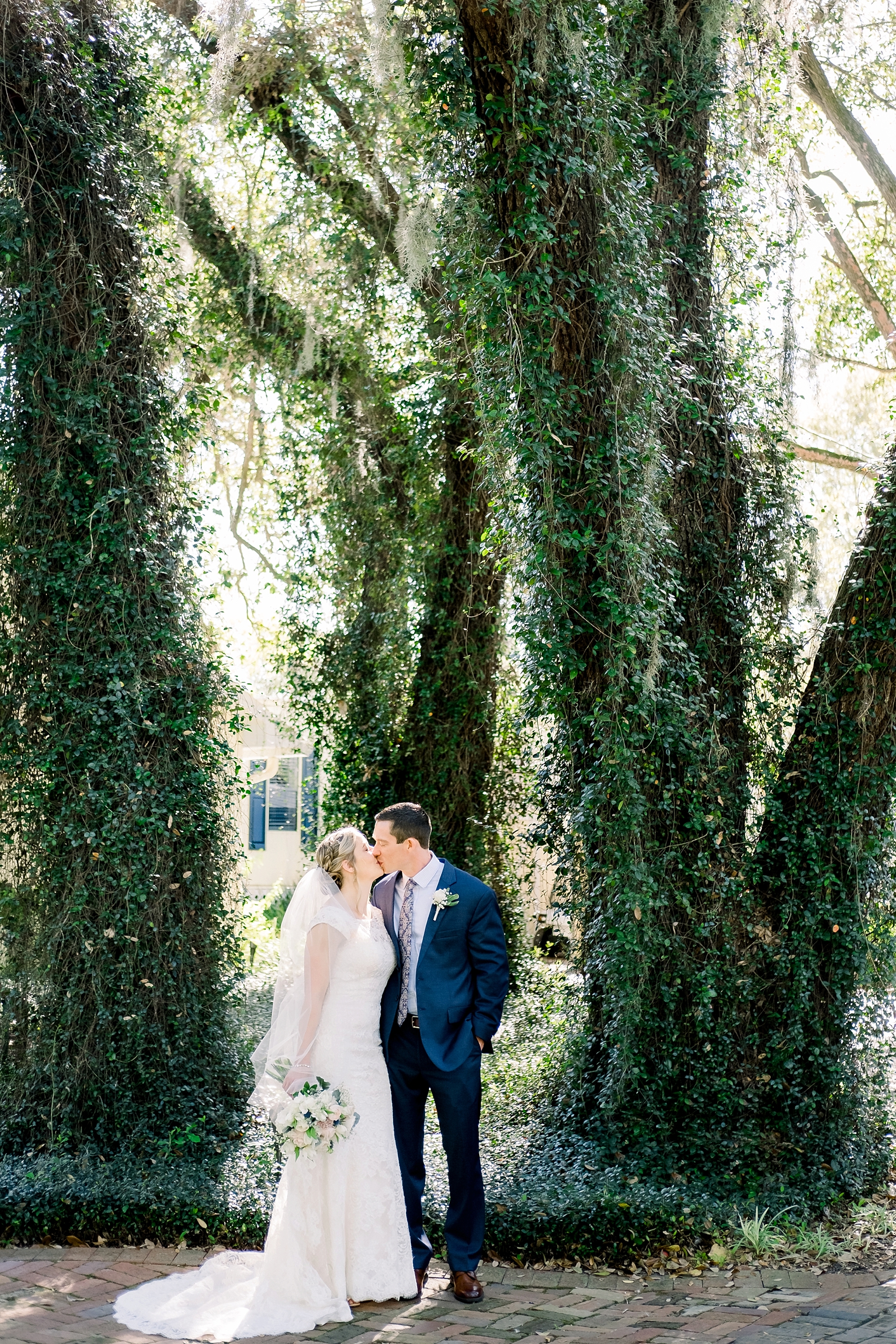 Brie and Groom kiss under the mossy trees on the Cross Creek Ranch property before their wedding