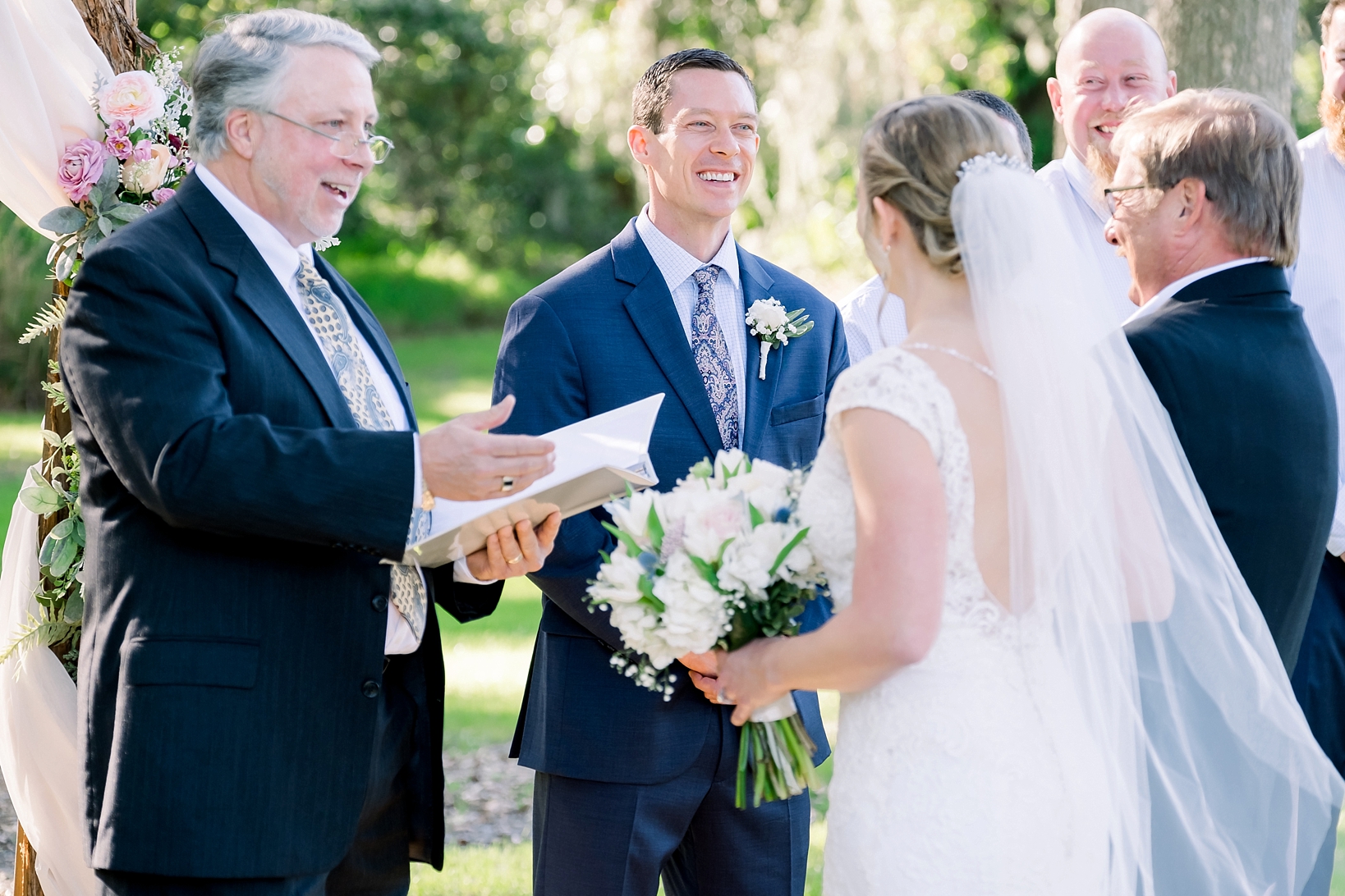 Groom shares a laugh with the Bride and her Dad during their wedding ceremony by Sarah and Ben Photography