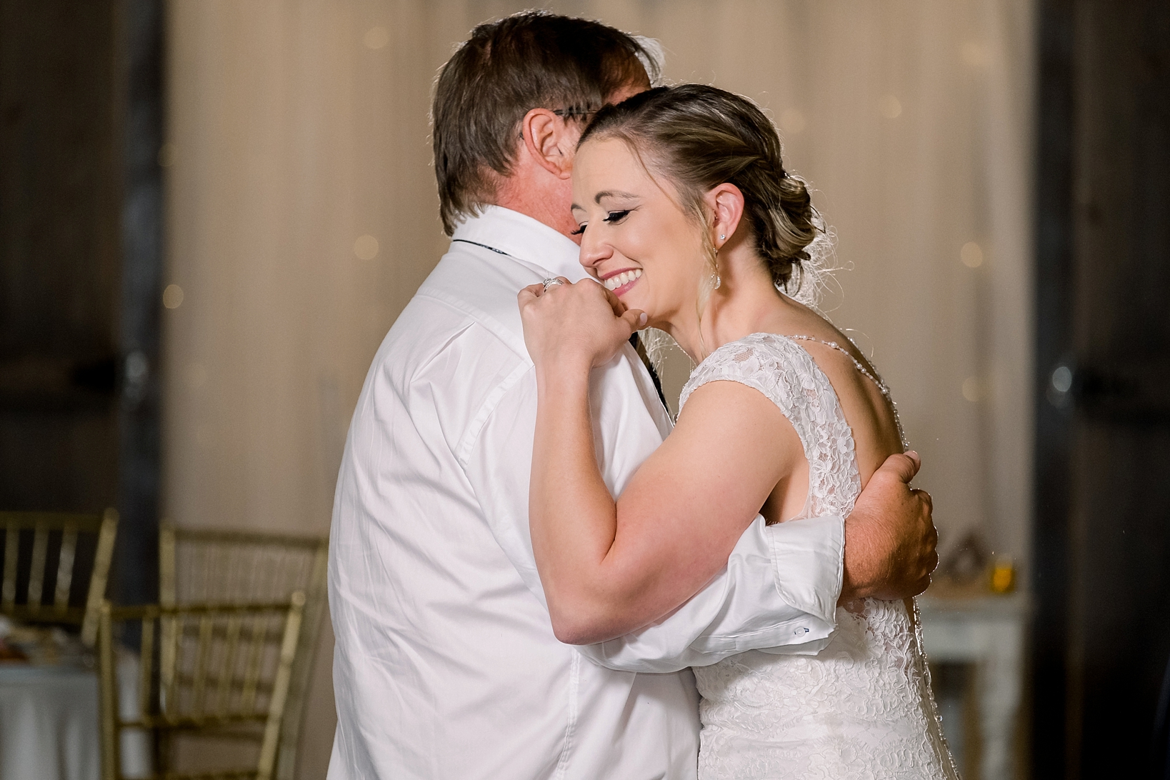 Father and daughter share a laugh during their dance during the wedding reception