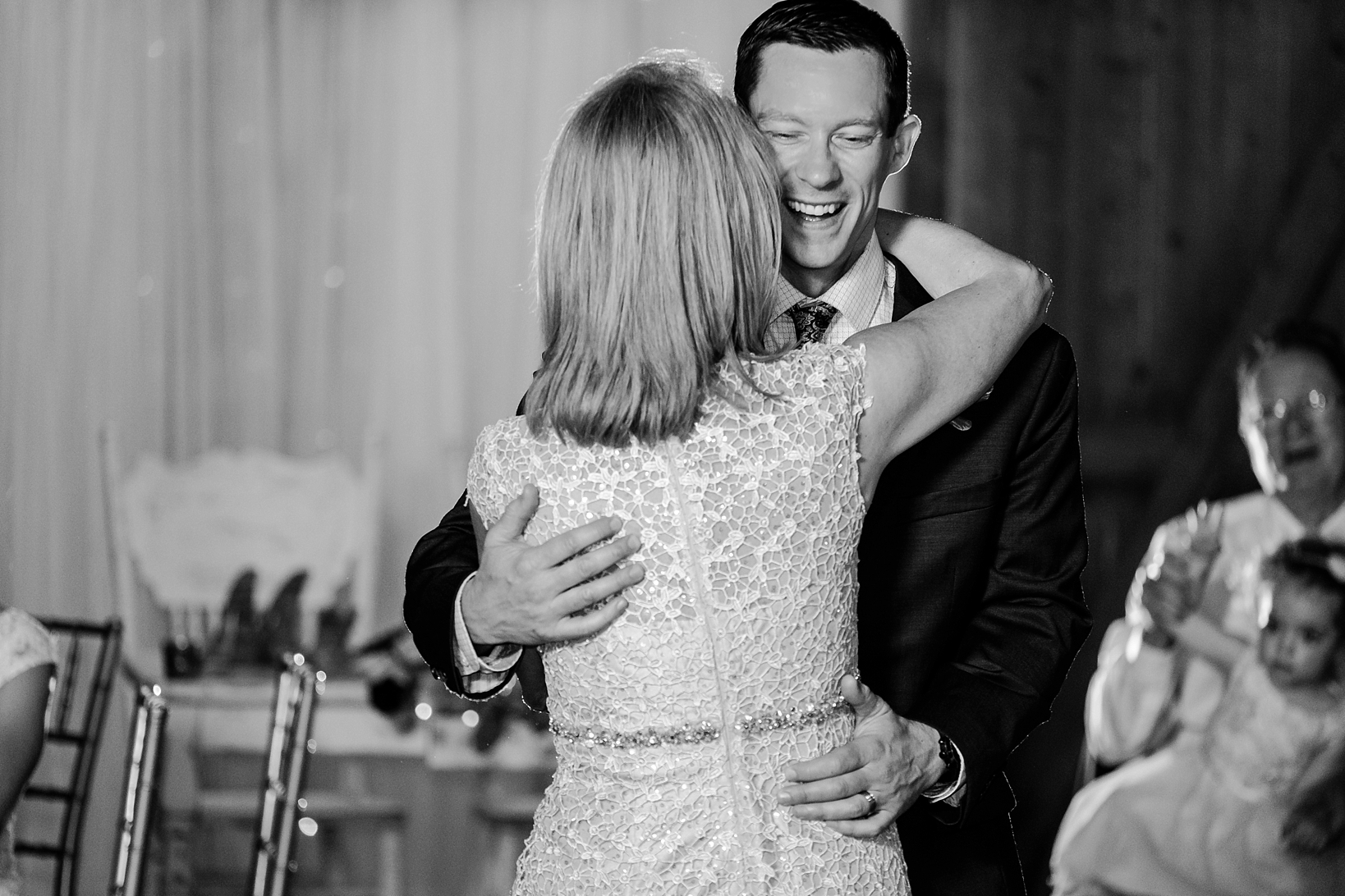 Groom laughs with his Mom during the reception of his wedding
