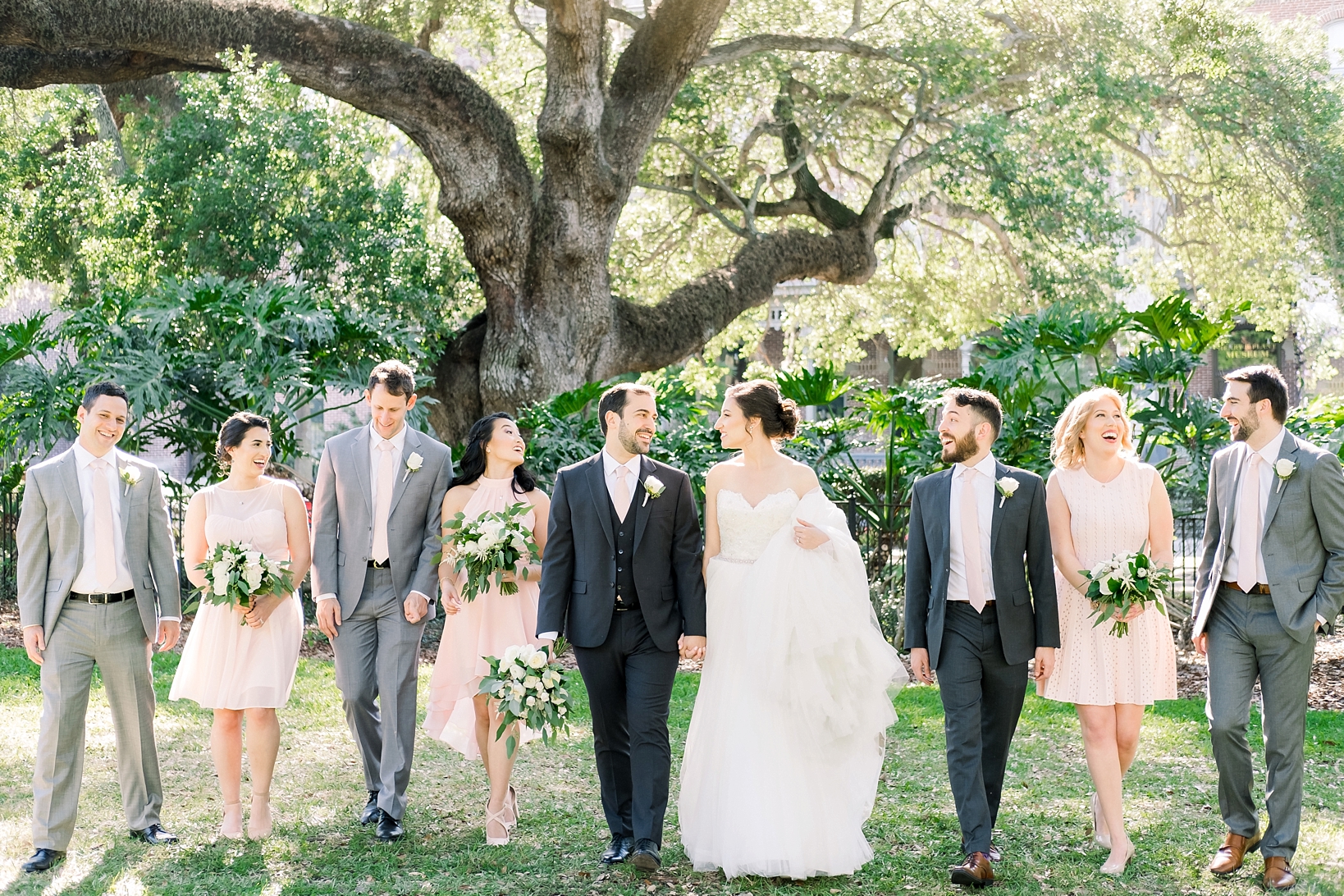 Entire bridal party walking across the lawn in a nice candid moment
