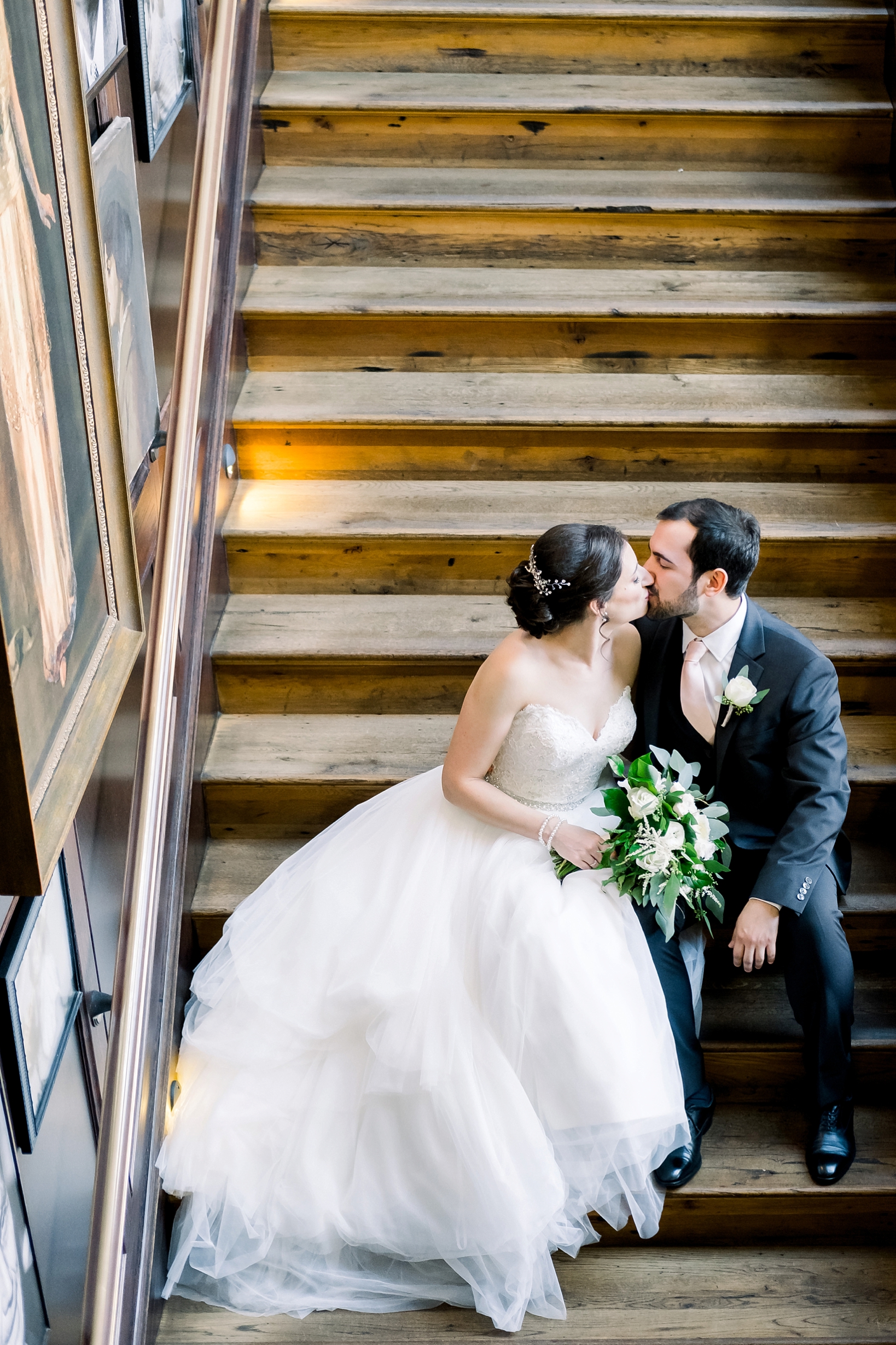 Bride and Groom kiss while sitting on the worn out staircase of the Oxford Exchange