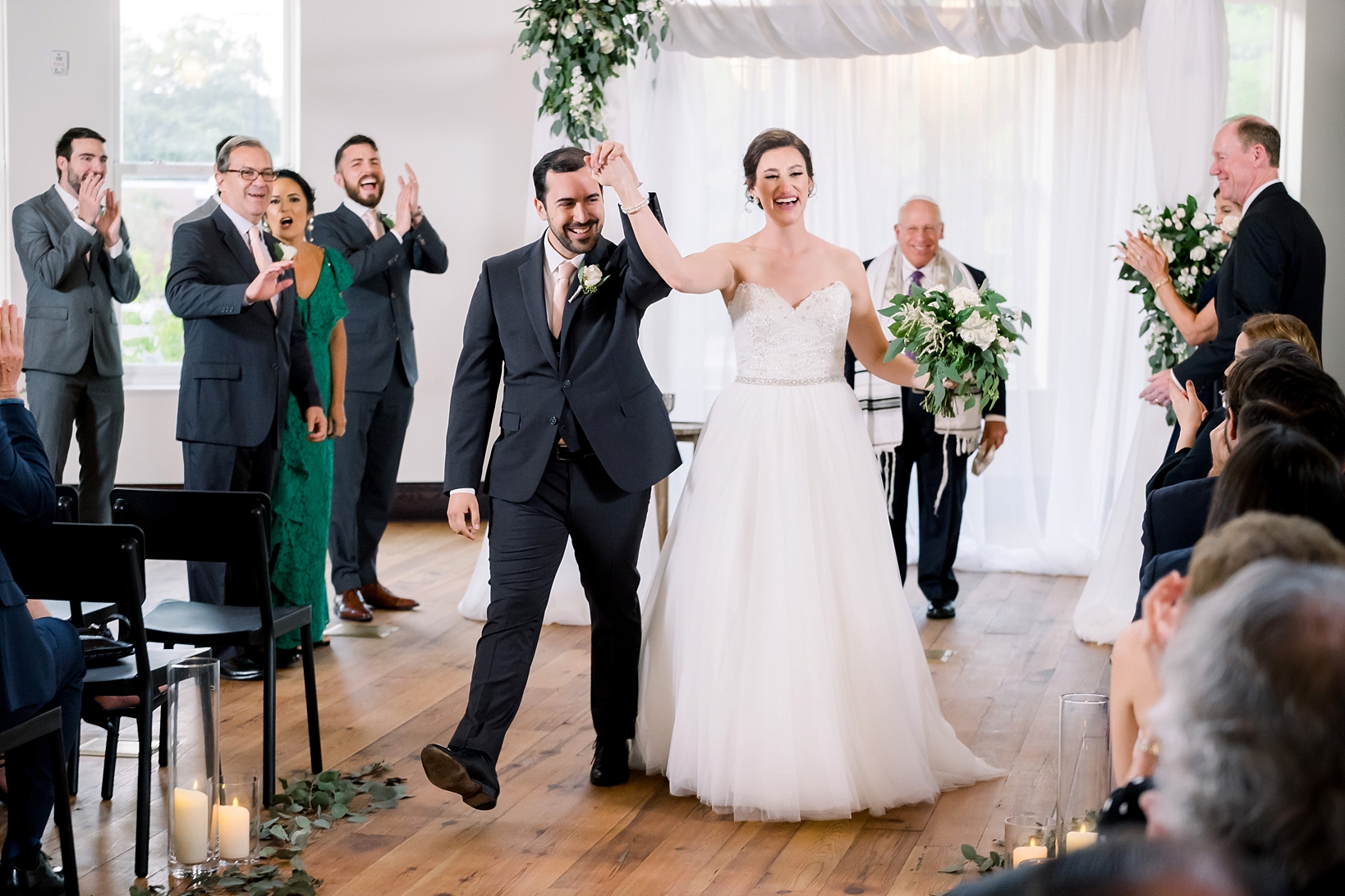 Husband and Wife walk back up the aisle on their wedding day surrounded by family and friends