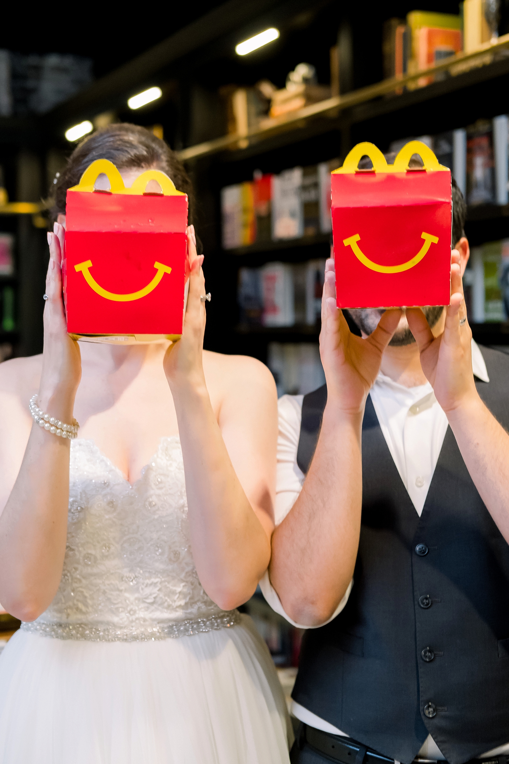 Bride and Groom hold up happy meals to show their joy on their wedding day