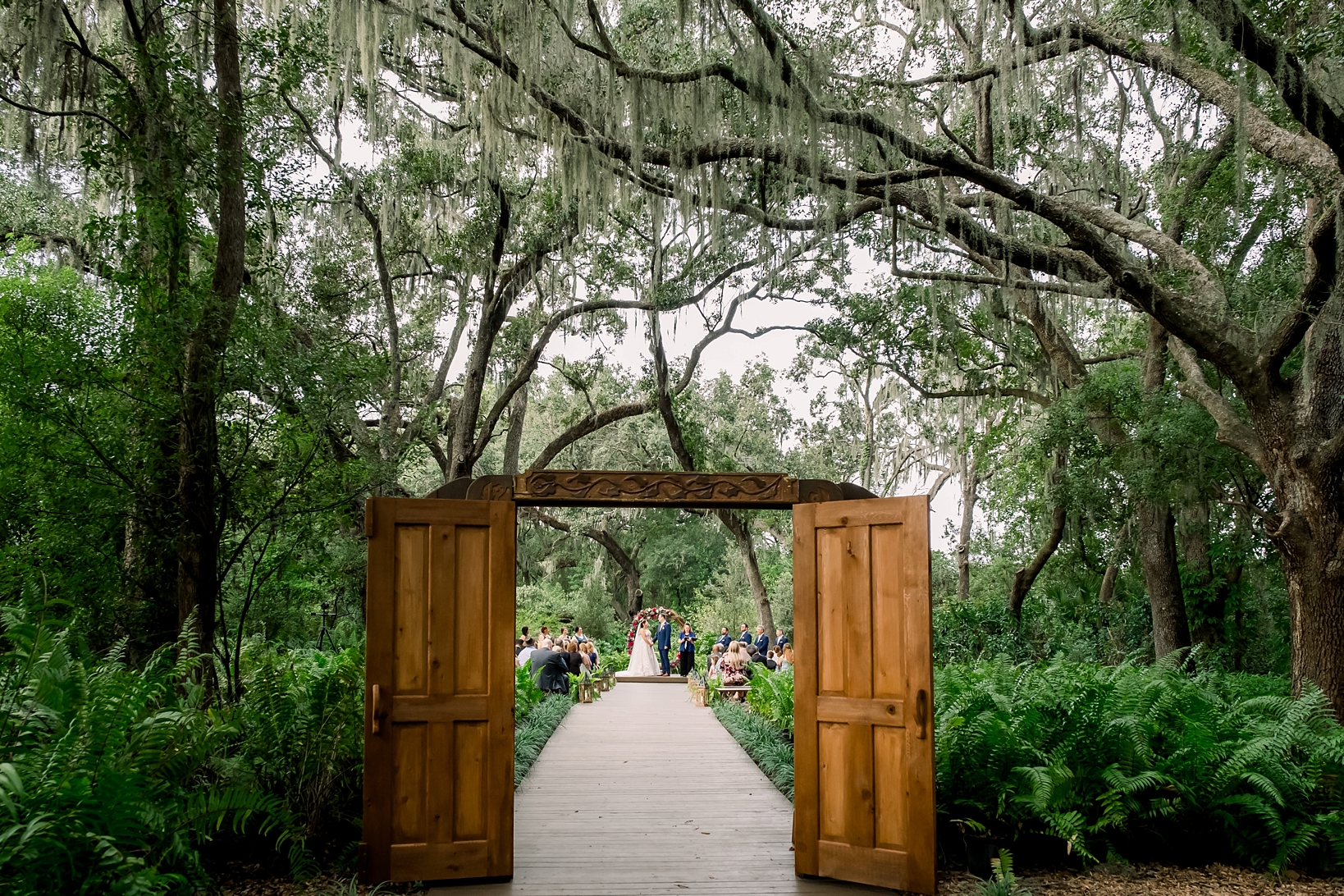 Wide shot of the enchanted forest during a cross creek wedding ceremony under the oak trees and spanish moss