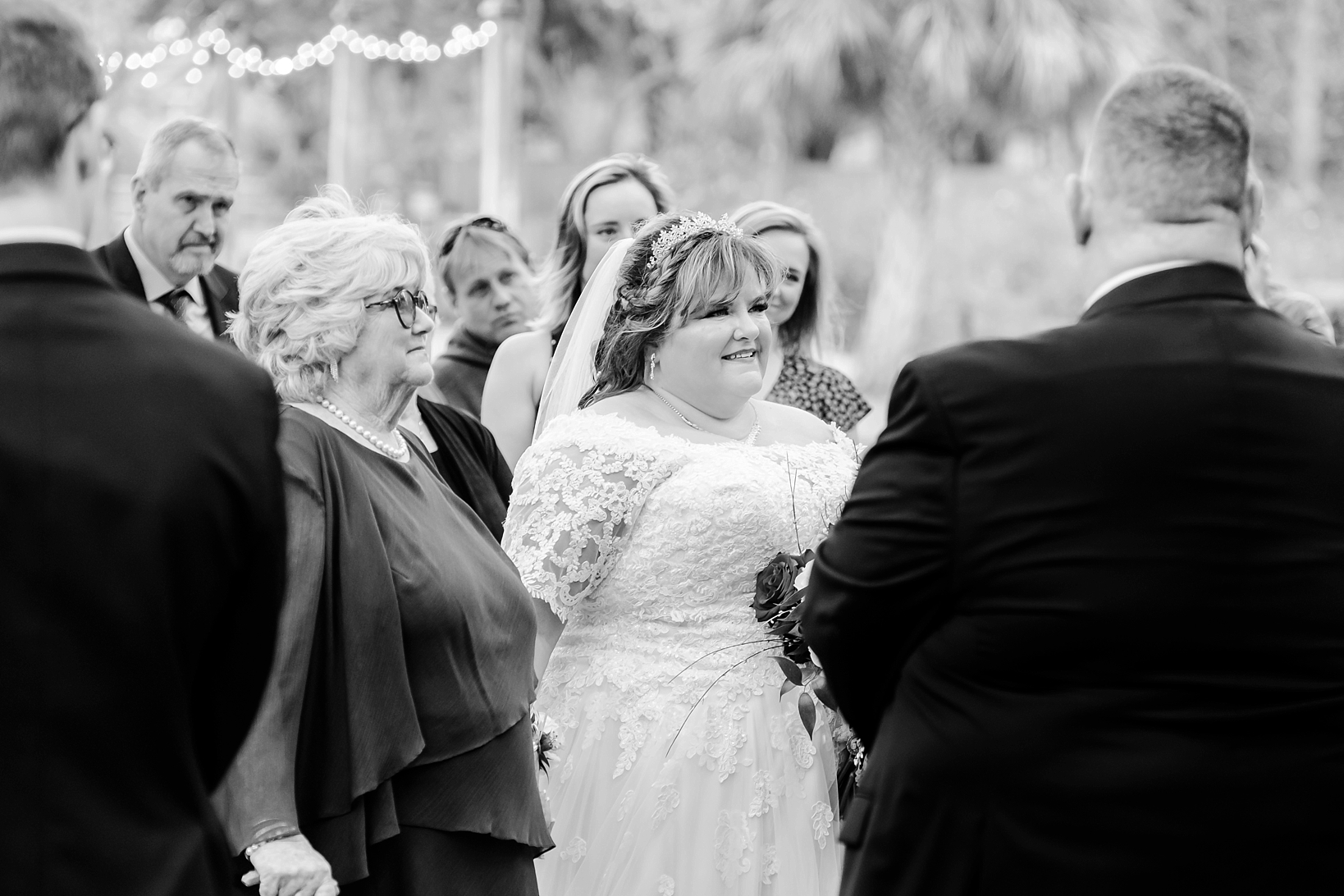 Bride looks at her groom during his vows to her during their wedding celebration
