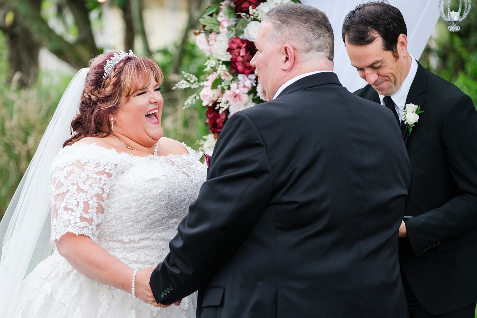 Bride laughs at the Groom during their wedding ceremony by Sarah and Ben Photography