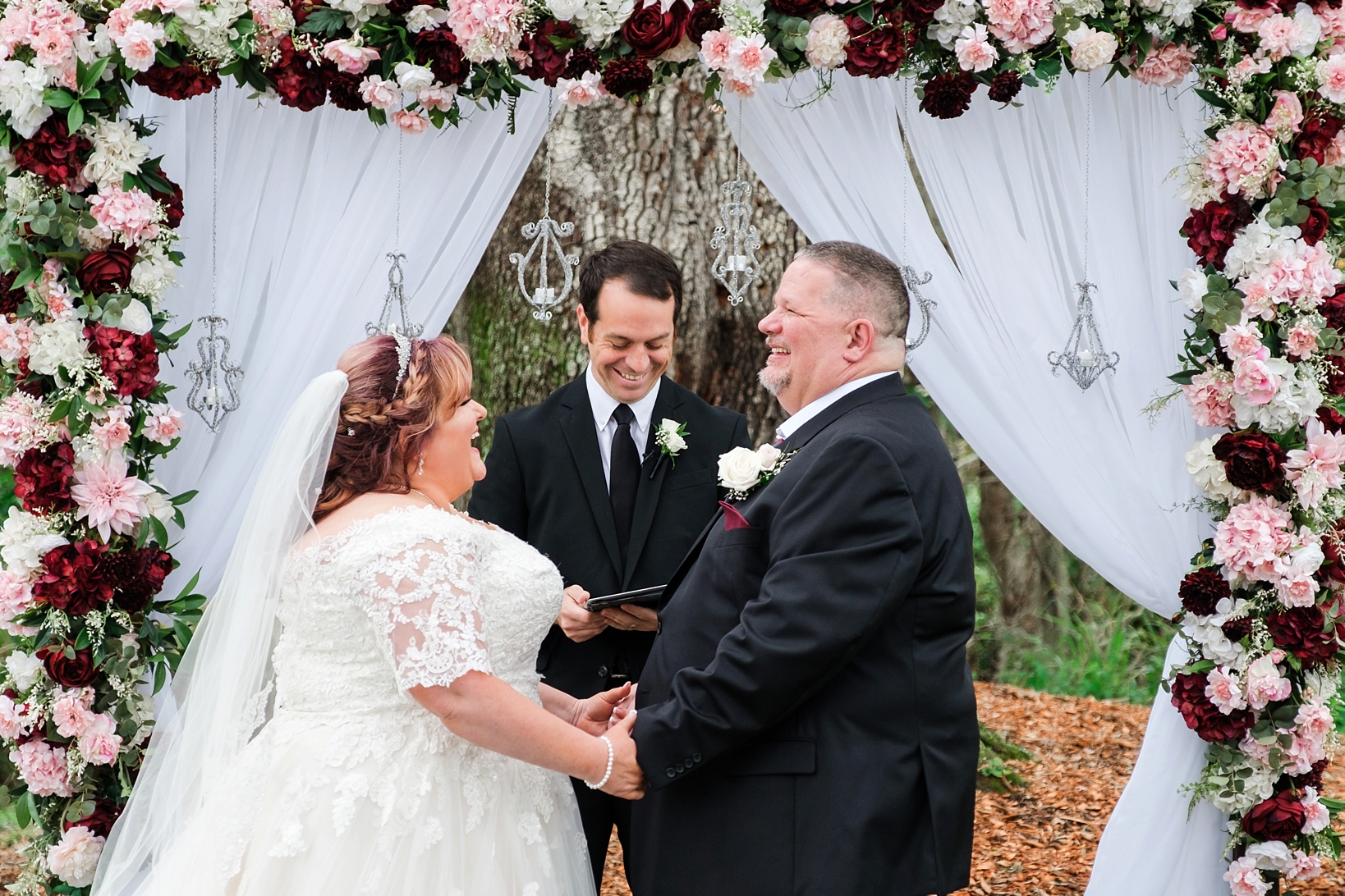 Groom laughs during his Bride's vows to him during their wedding ceremony