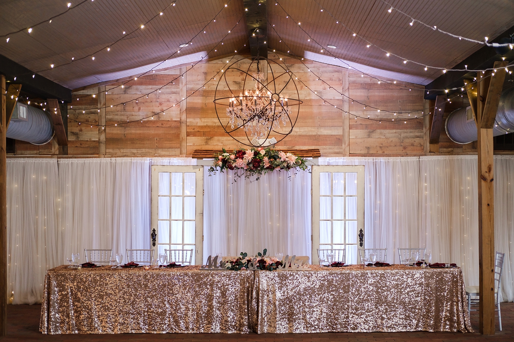 Head table under the string lights at Cross Creek Ranch