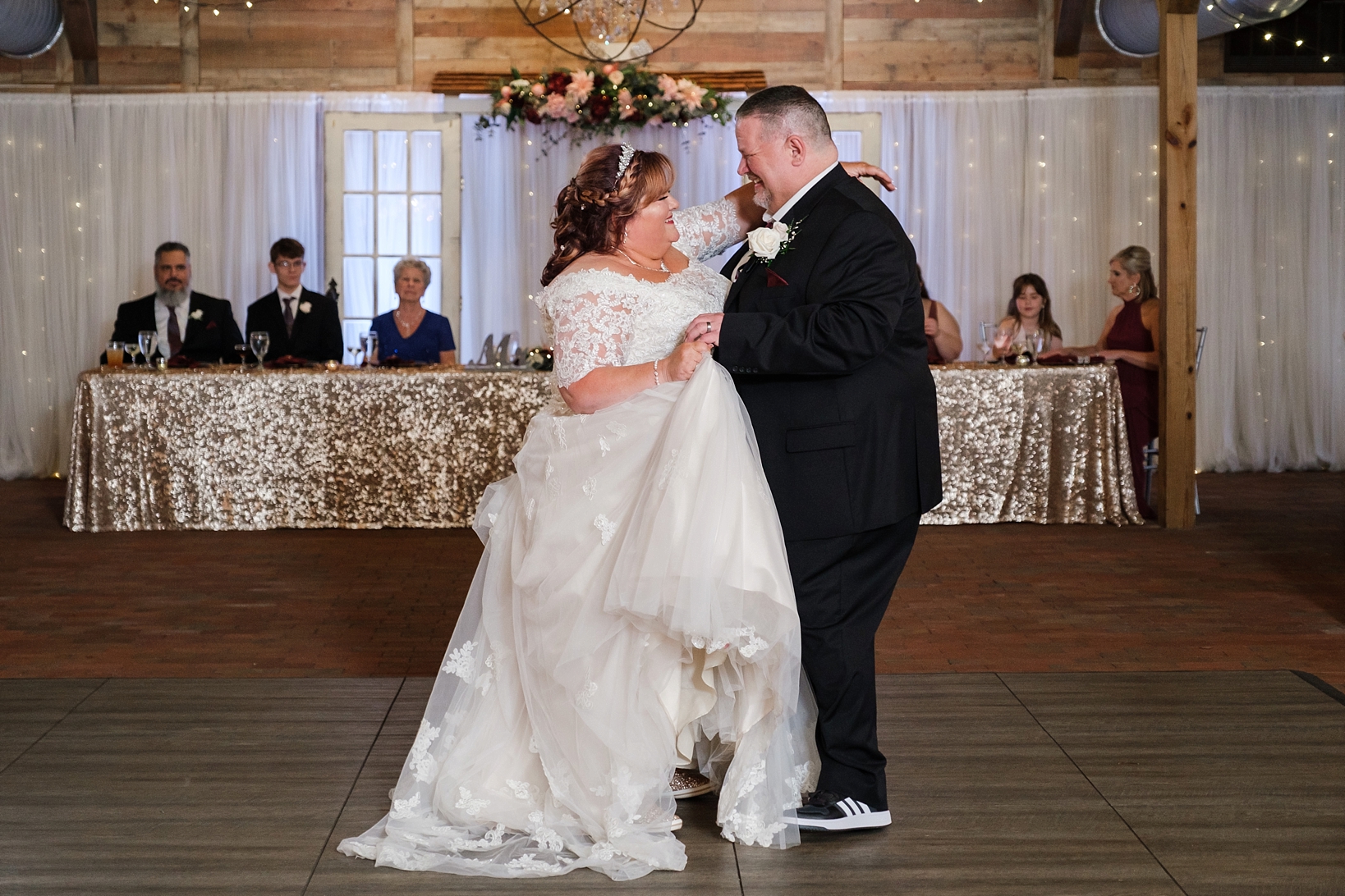 Bride and Groom dance during their cross creek wedding celebration as their family and friends watch on