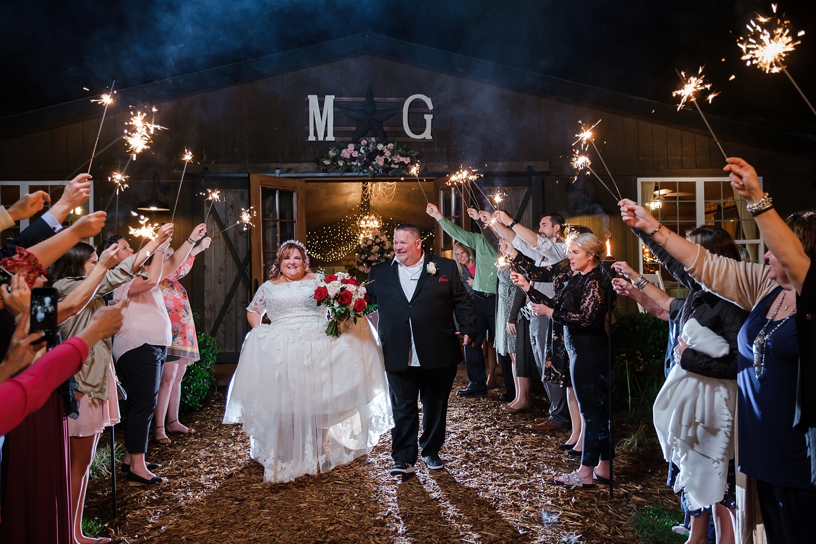 Bride and Groom exit their cross creek wedding celebration under a sky of sparklers held up by guests