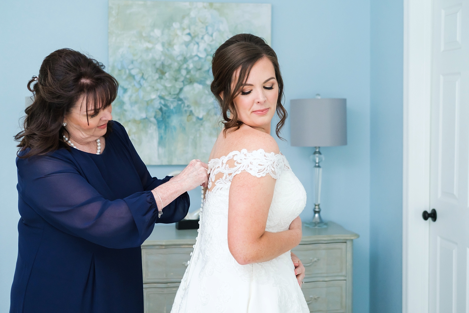 The Bride getting into her Wedding dress with the help of her Mom