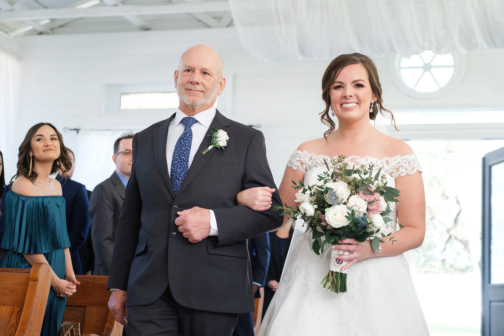 The Bride and her Dad smile as they walk down the aisle inside the chapel at Cross Creek Ranch