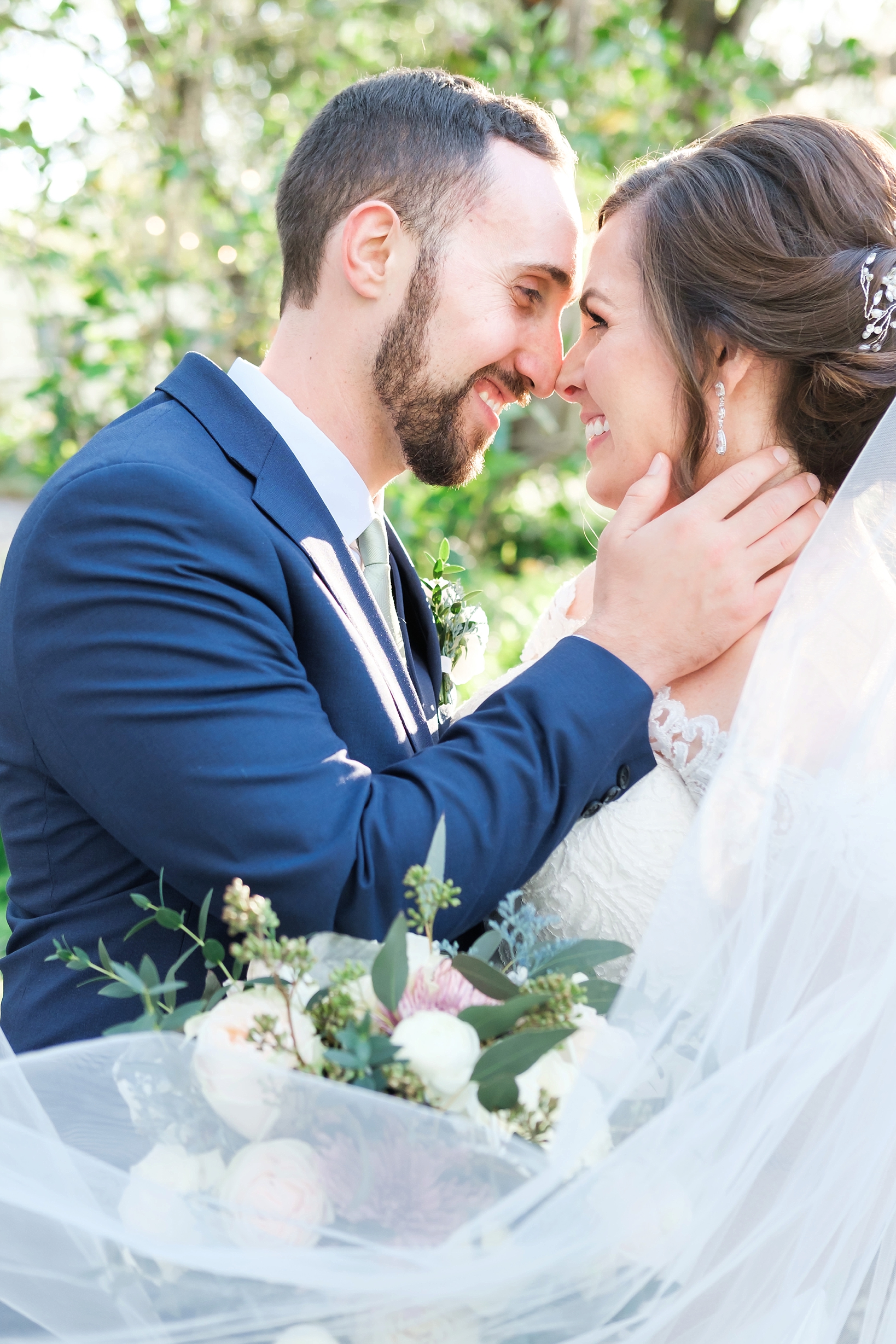 Bride and Groom touch their noses together as they smile