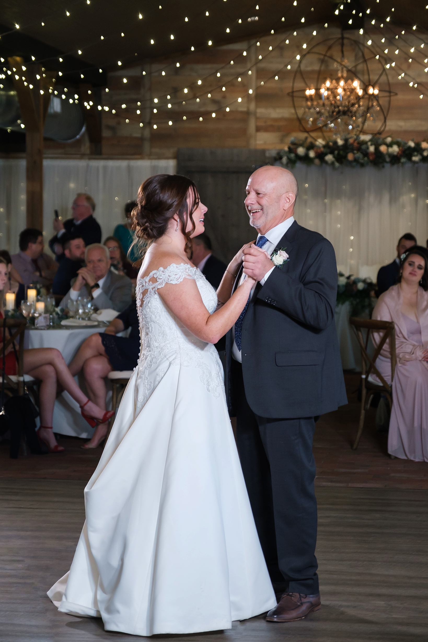 The Bride and her Father dance under the string lights of Cross Creek Ranch's reception barn