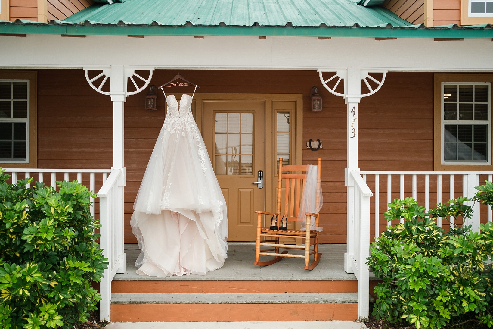 Brides strapless wedding gown hangs on the front porch at Westgate River Ranch