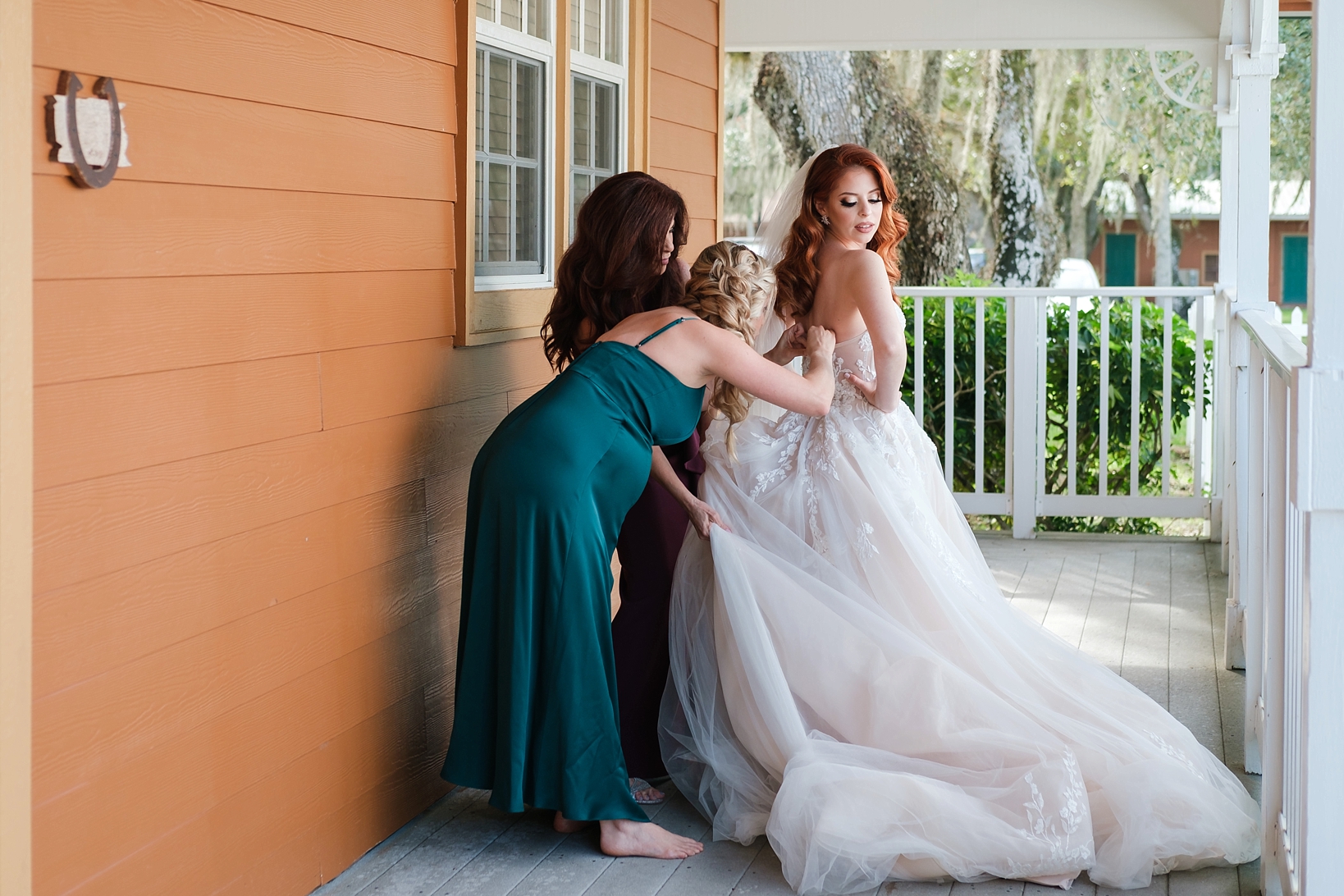 Maid of Honor helping her sister into her wedding gown before the wedding ceremony