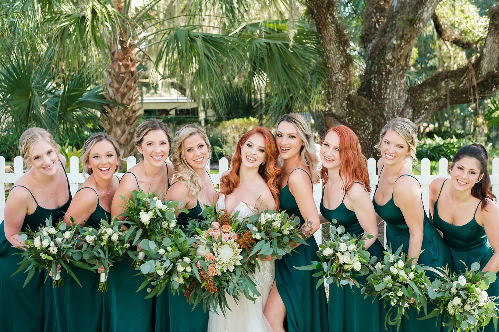 Bride and her Bridesmaids posing in a line under the Florida palm trees