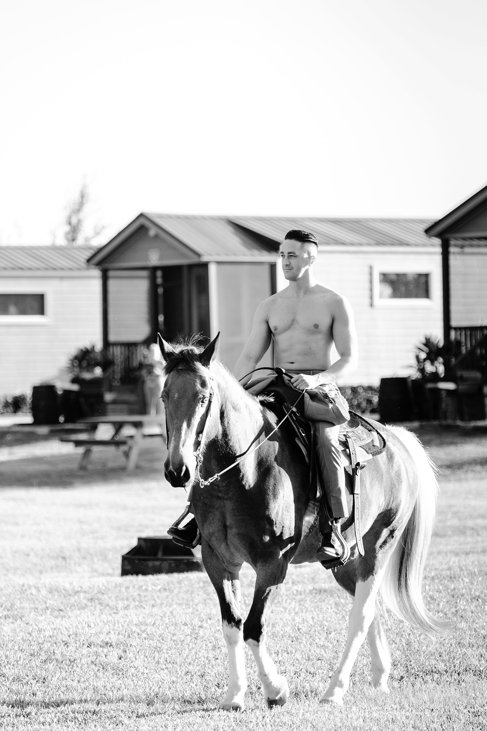 Shirtless Groom riding in on a horse to his wedding at Westgate River Ranch