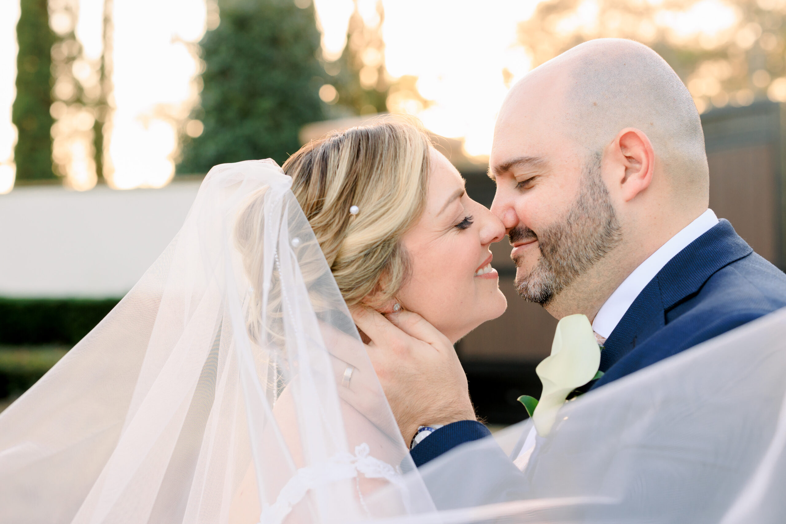 A Bride and Groom share an intimate kiss in the glow of the golden hour sunlight of Mision Lago Ranch by Sarah & Ben Photography