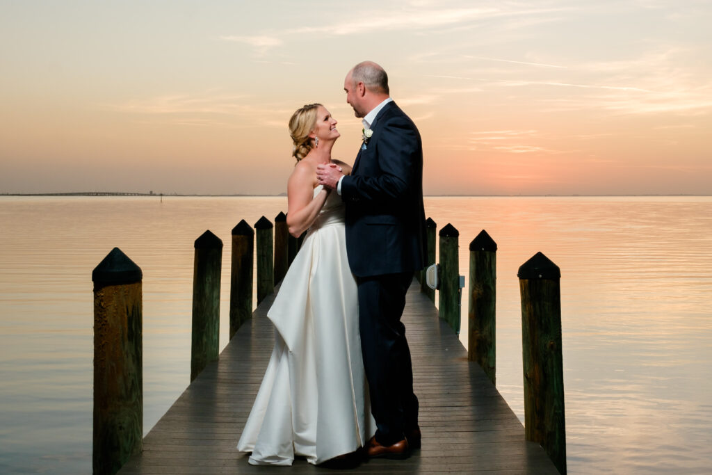 A Husband and Wife stand on a dock in Tampa Bay during the sunset