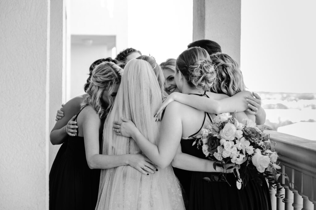 Bride and her Bridesmaids hug before the ceremony in classic Black and White