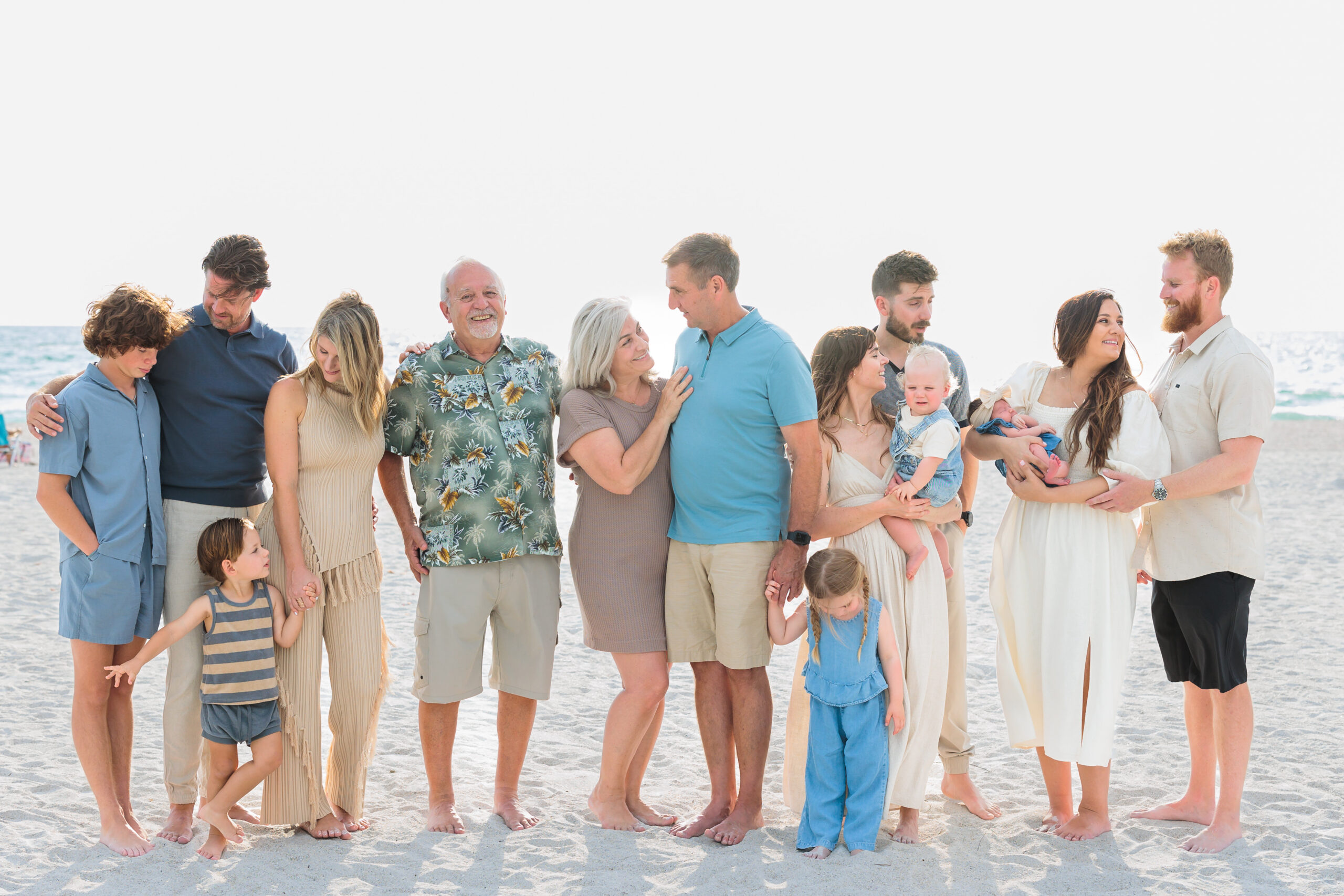 A multi-generational image of a family on a sandy Florida beach looking and laughing at each other