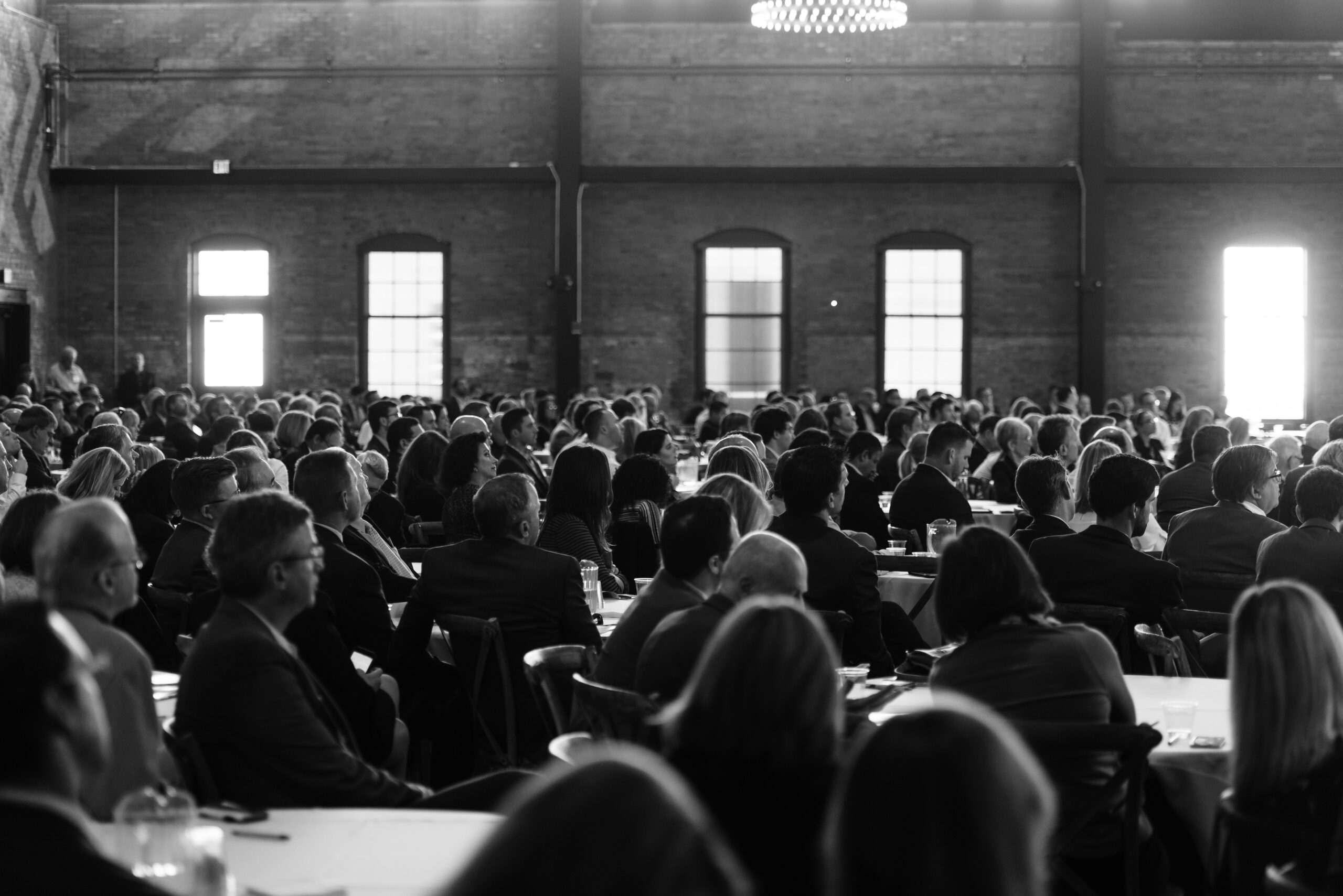 Black and White image of a crowd of people in Tampa Florida Armature Works ballroom during a business event