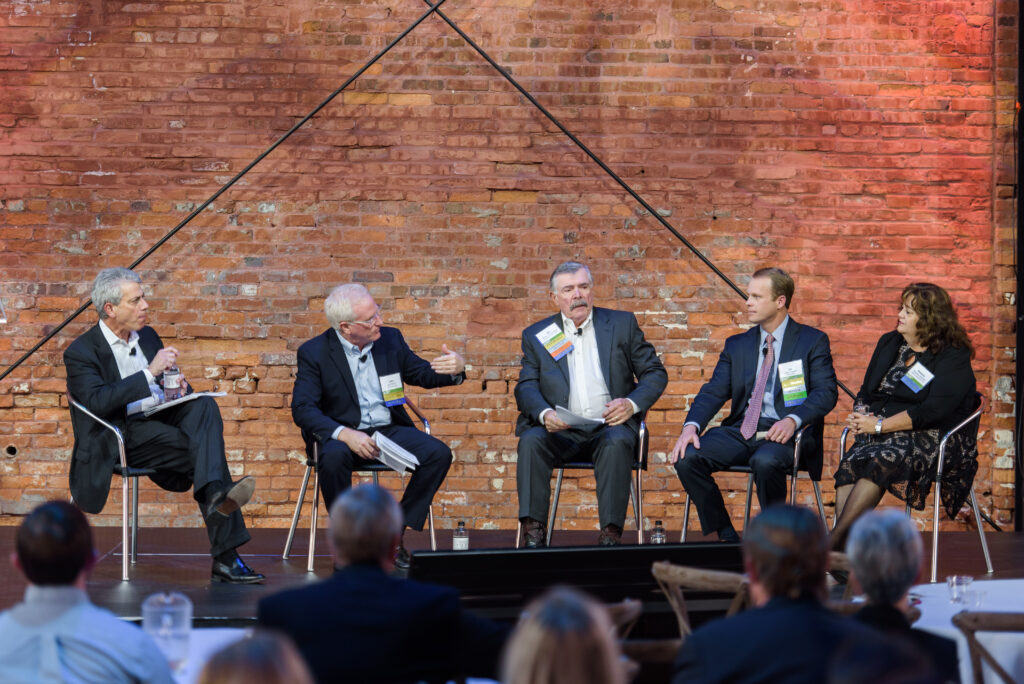 A group of business leaders from Tampa Bay sitting in stools in front of a brick wall